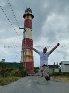 a man jumping in front of a lighthouse