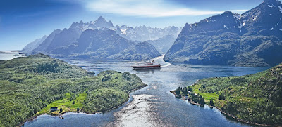 a ship in a river surrounded by mountains