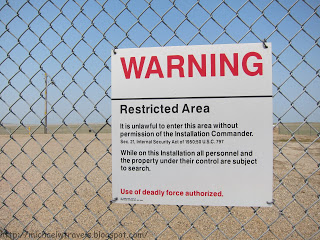 a warning sign on a chain link fence