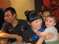 a group of people smiling and holding a baby