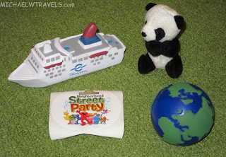 a toy panda bear and a toy ship next to a globe