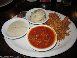 a plate of food with a side of mashed potatoes and sauce