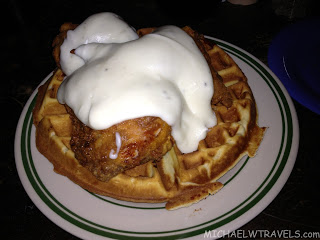 a chicken and waffle with white sauce on a plate