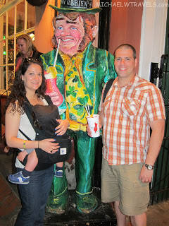 a man and woman posing with a statue of a leprechaun