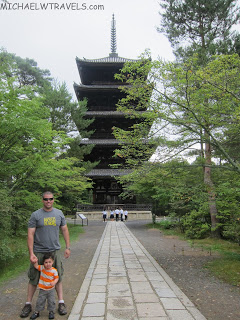 a man and child walking in front of a pagoda