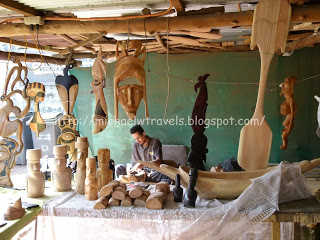 a man sitting at a table with wood carving