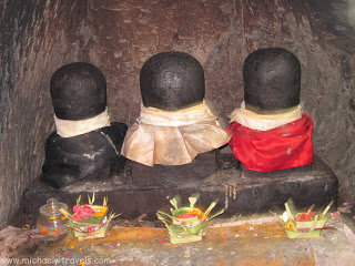 a group of black statues with red cloths