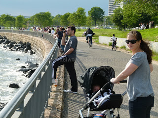 a woman pushing a stroller next to a railing