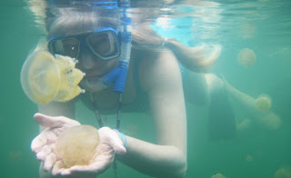 a woman in a mask and goggles holding a jellyfish