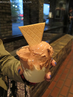 a person holding a cup of ice cream