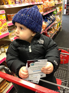 a child in a shopping cart holding a card