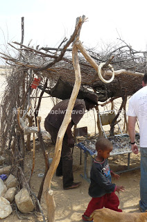 a man and child outside a hut
