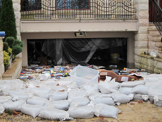 a pile of bags of trash outside a garage door