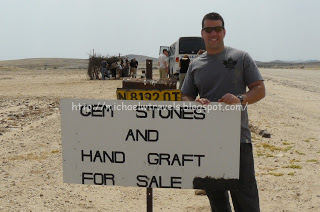 a man standing in the desert holding a sign