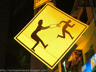a yellow sign with a person pushing a bottle