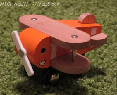 a wooden toy airplane on a green carpet
