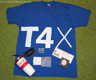 a blue shirt with white text and a drink and a bottle on a green surface